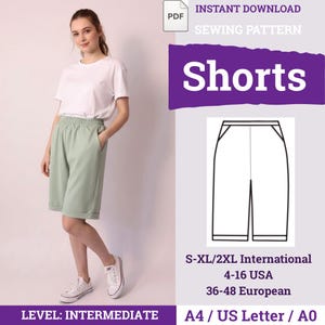 May include: A woman wearing a white t-shirt and mint green shorts. The image includes a sewing pattern for shorts, with the text "Shorts" in large white letters on a purple background. The pattern is for sizes S-XL/2XL.
