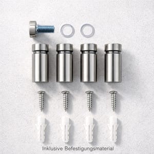 Op de afbeelding: Een set van vier cilindervormige zilverkleurige metalen afstandhouders, vier bijpassende schroeven, vier witte plastic pluggen en &eacute;&eacute;n bout met twee doorzichtige ringen. De tekst Inklusive Befestigungsmaterial staat onderaan de afbeelding.