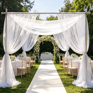May include: Outdoor wedding reception setup with white draping, floral arch, and tables. The scene includes a white aisle runner, gold chairs, and tables set for a celebration. The word "White" is written in cursive in the top right corner.