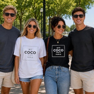 May include: Two individuals wear solid dark gray t-shirts with light-colored shorts, while two others wear t-shirts featuring a square graphic with the text N°7 COCO MADE IN PARIS. One wears a white t-shirt with black text, and one wears a black t-shirt with white text.