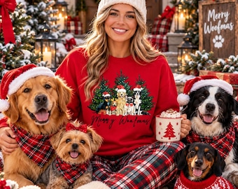 May include: A red sweatshirt featuring a graphic of dogs in Santa hats in front of Christmas trees with the text Merry Woofmas, paired with red and black plaid pajama pants. A white mug with a red tree print is held in one hand.