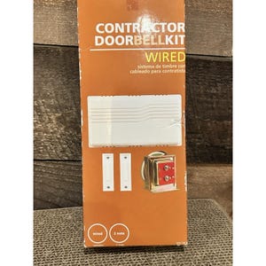 May include: A Contractor Doorbell Kit box with the word "WIRED" in large letters. The box contains a white doorbell chime, two white push buttons, and a transformer. The box also has the words "2 note" and "wired" printed on it.