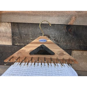 May include: A triangular wooden tie hanger featuring a gold-toned metal hook at the top and a silver-toned Lands' End brand plate in the center. The hanger includes multiple horizontal metal rods extending from the base to hold accessories.