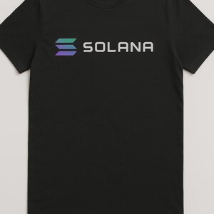 Könnte beinhalten: Schwarzes T-Shirt mit einem weißen Logo, auf dem "SOLANA" steht, und einer stilisierten Grafik aus drei übereinanderliegenden Linien in Blautönen und Grün.