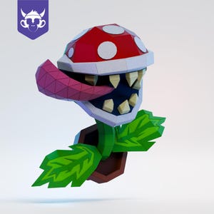 May include: A low-poly papercraft model of a carnivorous plant with a red, white-spotted head, sharp yellow teeth, and a purple tongue. The plant is set in a brown pot with green leaves extending from the base, featuring a purple monkey logo.