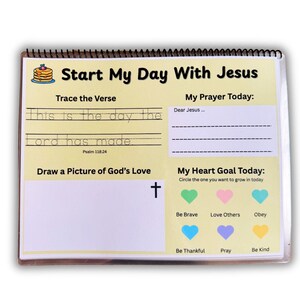 May include: Spiral-bound activity book with the title "Start My Day With Jesus." The pages include prompts for tracing a verse, writing a prayer, drawing, and setting a heart goal. Features a colorful design with a cross and heart icons.
