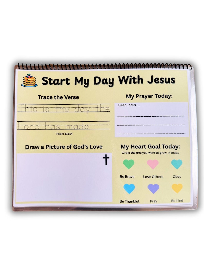 May include: Spiral-bound activity book with the title "Start My Day With Jesus." The pages include prompts for tracing a verse, writing a prayer, drawing, and setting a heart goal. Features a colorful design with a cross and heart icons.