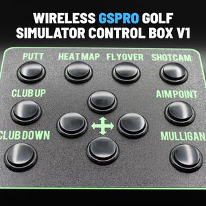 May include: A black control box for a golf simulator with the text "WIRELESS GSPRO GOLF SIMULATOR CONTROL BOX V1". It has several black buttons labeled "PUTT", "HEATMAP", "FLYOVER", "SHOTCAM", "CLUB UP", "AIMPOINT", "CLUB DOWN", and "MULLIGAN".