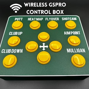 Peut inclure: Un boîtier de commande vert avec des boutons jaunes portant les mentions "PUTT", "HEATMAP", "FLYOVER", "SHOTCAM", "CLUB UP", "CLUB DOWN", "AIMPOINT" et "MULLIGAN". Le boîtier porte également un symbole sans fil et le texte "WIRELESS GSPRO CONTROL BOX".