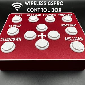 May include: A red control box with white buttons and the text "WIRELESS GSPRO CONTROL BOX." The buttons are labelled "PUTT," "HEATMAP," "FLYOVER," "SHOTCAM," "CLUB UP," "AIM POINT," "CLUB DOWN," and "MULLIGAN."
