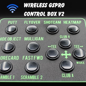 May include: Black control box with green trim and multiple black buttons labeled with golf-related functions. The text "WIRELESS GSPRO CONTROL BOX V2" is displayed at the top, along with a wireless symbol.