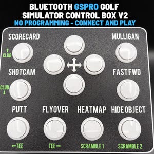 May include: A black Bluetooth GSPro golf simulator control box V2 with white circular buttons. The text reads: BLUETOOTH GSPRO GOLF SIMULATOR CONTROL BOX V2, NO PROGRAMMING - CONNECT AND PLAY, SCORECARD, MULLIGAN, SHOTCAM, FASTFWD, PUTT, FLYOVER, HEATMAP, HIDE OBJECT, CLUB, TEE, SCRAMBLE.