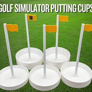 May include: Five white circular golf simulator putting cups with white vertical poles and yellow flags. One flag is marked with the number 18. The text GOLF SIMULATOR PUTTING CUPS is displayed in white capital letters at the top of the image.