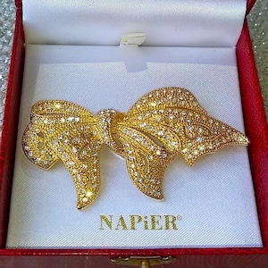 Puede incluir: Una taza de cerámica blanca con un asa negra y el texto "But First, Coffee" en negro en negrita. La taza está sobre una superficie blanca.