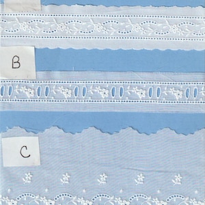 May include: Three samples of white cotton lace trim with different patterns. The top sample has a scalloped edge and a repeating pattern of small flowers and ovals. The middle sample has a straight edge and a repeating pattern of small flowers and circles. The bottom sample has a scalloped edge and a repeating pattern of small flowers and ovals.