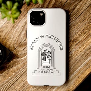 Könnte beinhalten: Weißes Handycase mit dem Text "WOMEN IN ARCHITECTURE" in einem Halbkreis über einer schwarz-weißen Grafik einer Schachfigur mit karierter Schleife. Der Text "FORM. FUNCTION. RULE THEM ALL" steht darunter.