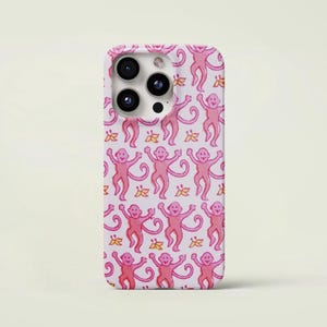May include: A pink phone case with a repeating pattern of pink monkeys and yellow floral accents. The monkeys are in a playful pose with their arms raised. The case has a glossy finish.