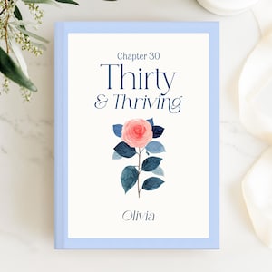 Puede incluir: Una portada de libro con marco azul claro con el texto "Chapter 30 Thirty & Thriving" y el nombre "Olivia". Una ilustración de acuarela de una rosa rosa con hojas y tallo azules está centrada en la portada.