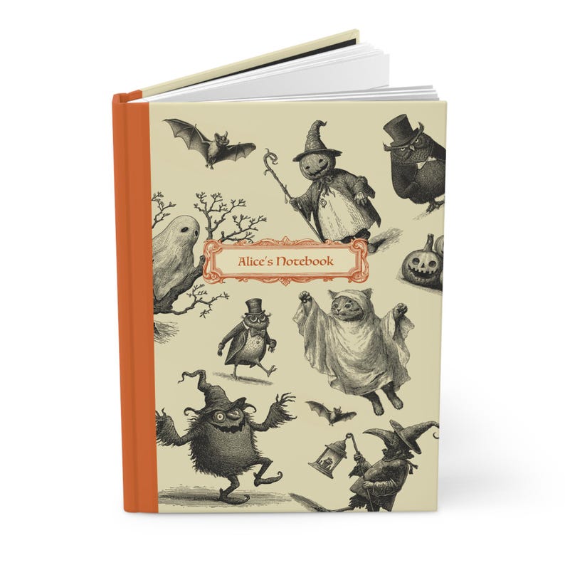 May include: A hardback notebook with an orange spine and a cream-coloured cover featuring vintage Halloween illustrations. The cover includes images of bats, ghosts, and other spooky characters. The text "Alice's Notebook" is displayed in a decorative frame.