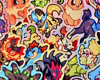 May include: A selection of colourful cartoon stickers featuring various creatures. The stickers showcase a variety of designs with vibrant colours, including orange, blue, green, and yellow. The stickers are cut out with a white border.