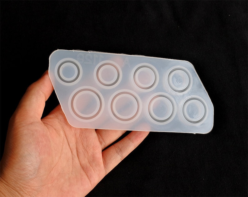 May include: A clear silicone mould with eight round cavities for making resin rings. The mould is flexible and has a smooth surface.