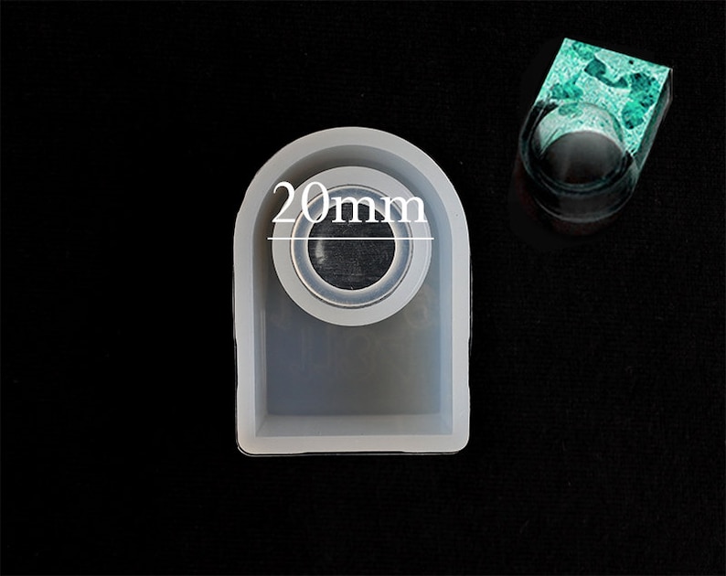 May include: A white silicone mould for making resin rings. The mould is shaped like a ring and has a 20mm diameter opening.