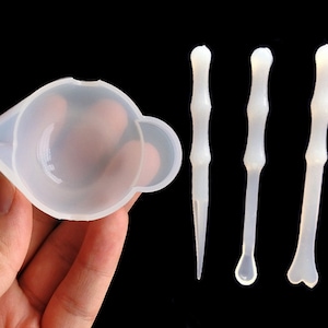 May include: A set of three white silicone tools for resin crafts. The set includes a small cup and two tools with different tip shapes.