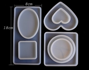 May include: Four silicone molds for resin casting. The molds are shaped like a heart, a square, a rectangle, and an oval. The molds are 8 cm wide and 18 cm tall.