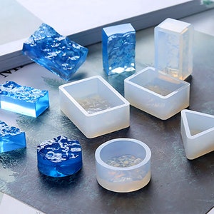 May include: A set of 10 clear silicone moulds for resin casting. The moulds are in various shapes, including a circle, square, rectangle, triangle, and irregular shapes. The moulds are perfect for creating unique jewellery, home decor, and other crafts.