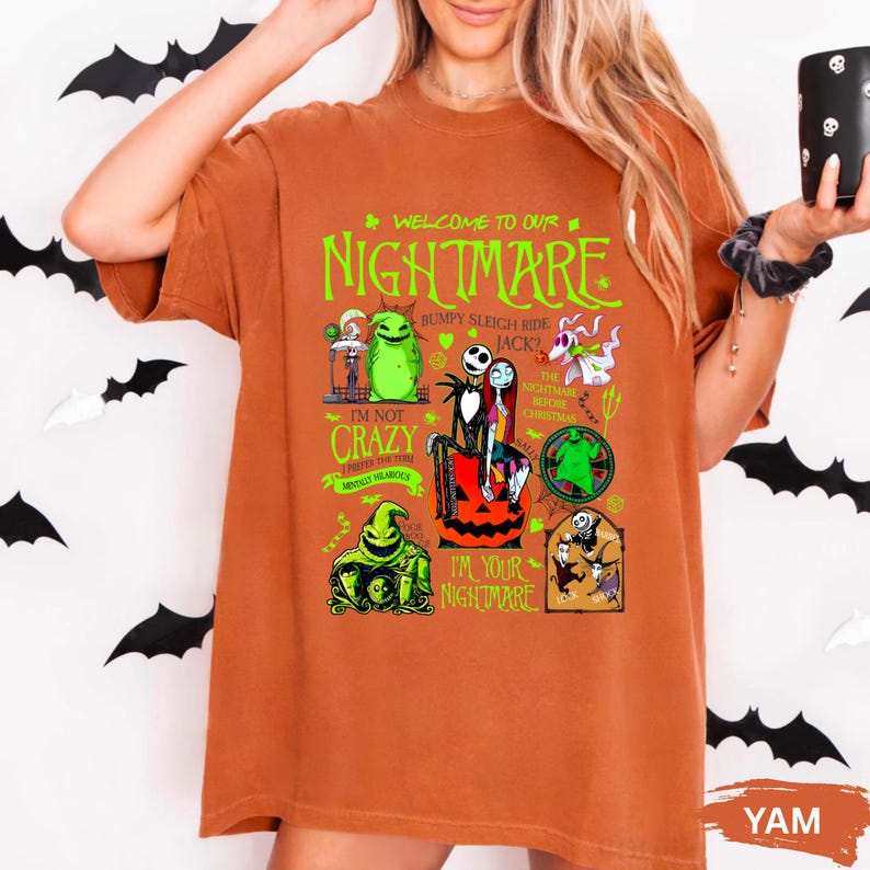 Puede incluir: Una camiseta naranja quemado con un gr&aacute;fico de "Pesadilla antes de Navidad". El dise&ntilde;o incluye el texto "WELCOME TO OUR NIGHTMARE" e ilustraciones de personajes en verde y negro. La camiseta tiene mangas cortas.