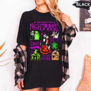 Puede incluir: Camiseta negra con personajes y texto de "Pesadilla antes de Navidad". El dise&ntilde;o incluye a Jack Skellington, Sally y otros personajes ic&oacute;nicos. El texto dice "Welcome to our Nightmare" y "I'm Your Nightmare."