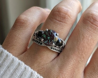 Conjunto de boda gótico con calavera, anillo de moissanita y alejandrita de talla redonda de 1 quilate, banda de esqueleto negra, joyería nupcial alternativa, propuesta de estética oscura.