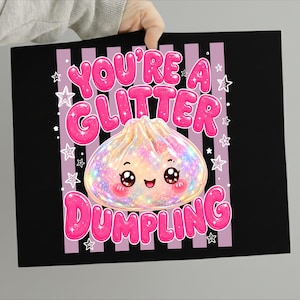 May include: Black poster with the text "YOU'RE A GLITTER DUMPLING" in pink bubble letters. A cute, glittery dumpling illustration is in the center, with pink and white striped accents and star details.