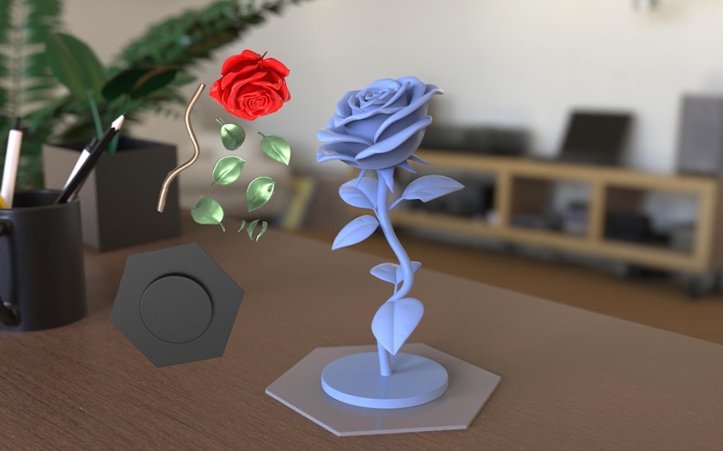 May include: A light blue rose sculpture with a stem and leaves stands on a hexagonal base. Nearby, a separate red rose head, a curved metallic stem, several green leaves, and a black hexagonal component are arranged as individual parts.