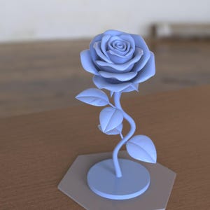 May include: A light blue rose sculpture featuring a detailed flower head with layered petals, a curved stem, and three leaves. The rose is attached to a circular base, which is mounted on a flat, light gray hexagonal platform for stability.
