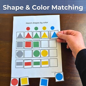 Puede incluir: Una hoja de trabajo educativa blanca titulada Match shapes by color con una cuadrícula de cuadrados vacíos y varias formas de colores, incluyendo triángulos, cuadrados, círculos y rectángulos rojos, verdes, amarillos, azules y grises.