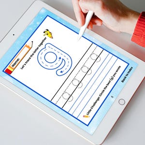 May include: A white tablet displaying a handwriting practice sheet with the letter "g". The sheet includes dotted lines for tracing and the text "Let's trace the letter together". A hand with a stylus is writing on the screen. The tablet is on a white surface.
