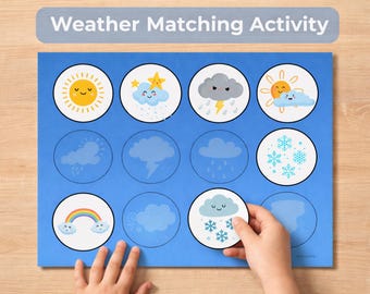 May include: A blue weather matching activity game with illustrated weather symbols, including a sun, clouds, rain, and snowflakes. The text "Weather Matching Activity" is at the top. A hand is holding a snowflake card.