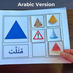 May include: A white paper with a blue triangle, pizza, a tortilla chip, a warning sign, a party hat, and a watermelon slice. The word "مثلث" is written in Arabic. The image is held by a hand.