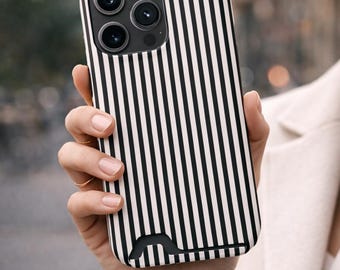 May include: A smartphone case featuring a vertical black and white striped pattern. The case has a rectangular cutout for the camera module at the top left and a small, curved black cutout at the bottom edge, designed to accommodate device ports.