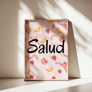 Puede incluir: Una impresi&oacute;n enmarcada con la palabra "Salud" en escritura negra. El fondo es rosa claro con ilustraciones de fresas, rodajas de naranja y rodajas de manzana. La impresi&oacute;n est&aacute; en un marco de madera.