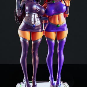May include: A pair of statues of female characters in purple and silver outfits. One figure has black hair, the other red. Both are on a platform with green and white accents. The statues are detailed and stylized.