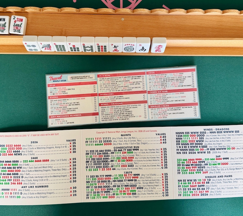 May include: A wooden Mahjong set with tiles and a game guide. The tiles are white with black symbols and numbers. The guide displays scoring combinations and rules for the game.