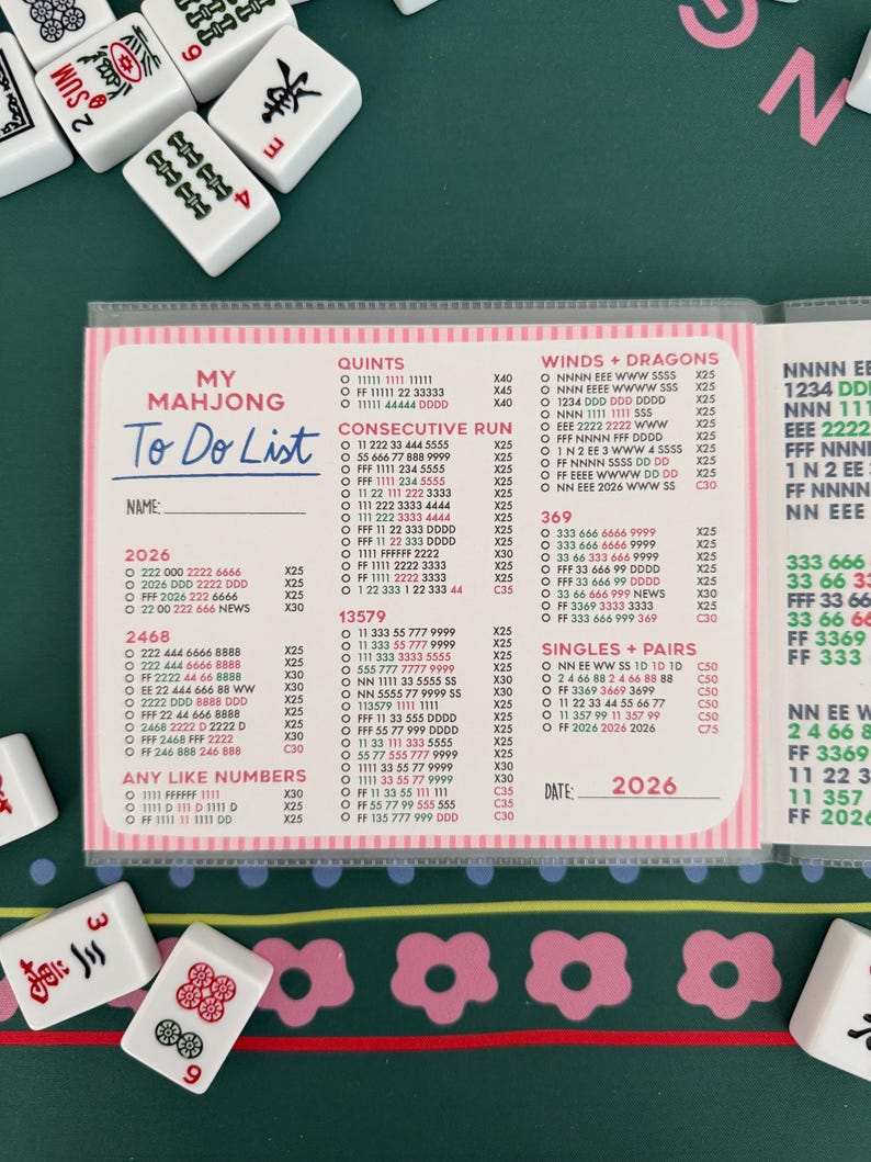 K&ouml;nnte beinhalten: Ein Mahjong To Do List Notizblock mit rosa Akzenten, der Zahlenkombinationen und Spielstrategien zeigt. Der Notizblock enth&auml;lt das Jahr 2026 und ist von Mahjong-Steinen umgeben.