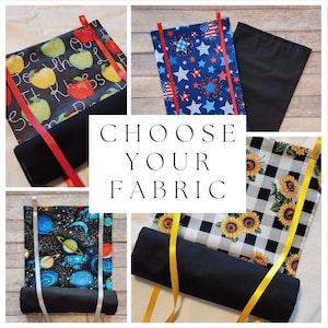 Puede incluir: Cuatro opciones de tela diferentes para un proyecto de bricolaje. Las telas incluyen un patrón de cuadros blanco y negro con girasoles, una tela azul con estrellas blancas, una tela negra con planetas y estrellas de colores, y una tela negra con un alfabeto y manzanas de colores.