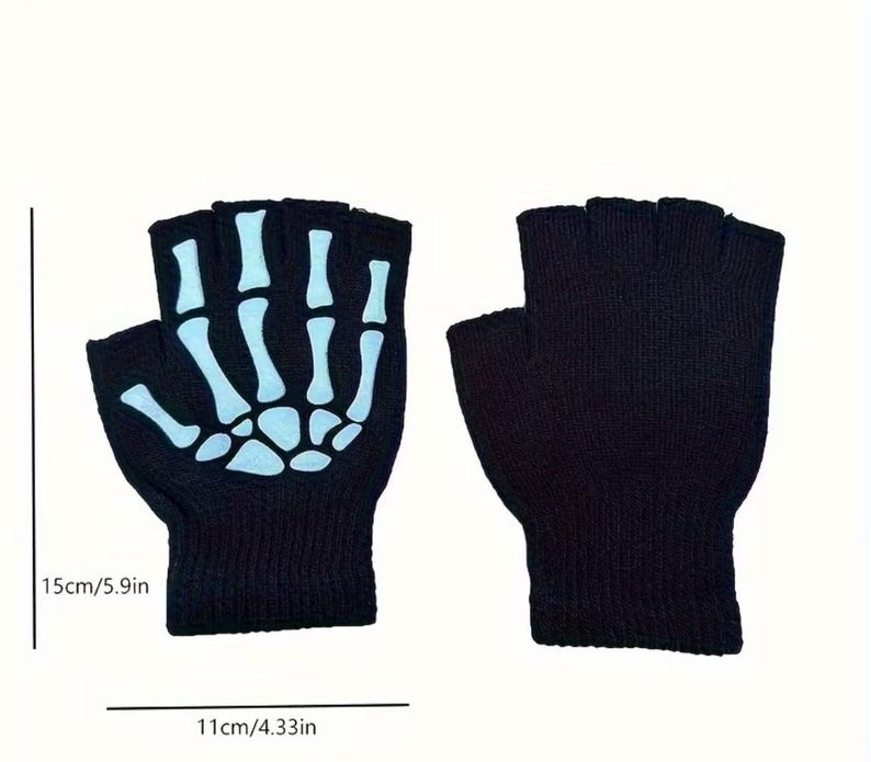 K&ouml;nnte beinhalten: Ein Paar schwarze fingerlose Handschuhe mit einem wei&szlig;en Skeletthand-Motiv auf dem Handr&uuml;cken eines Handschuhs. Die Handschuhe sind 15 cm hoch und 11 cm breit, wie durch die sichtbaren Messlinien und den Text angegeben.