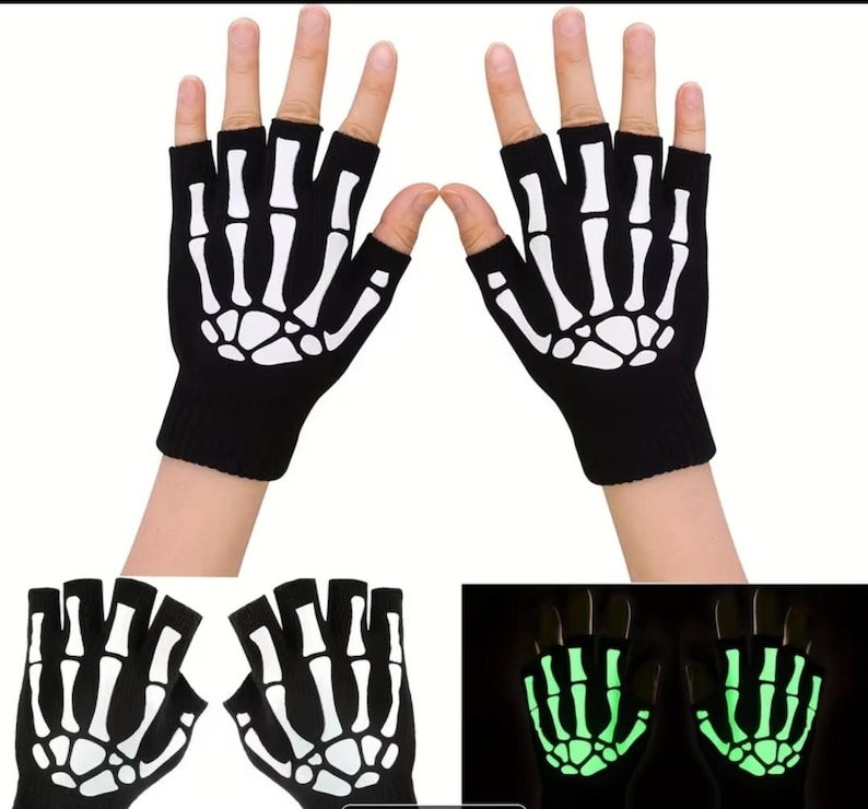 K&ouml;nnte beinhalten: Ein Paar schwarze fingerlose Handschuhe mit einem wei&szlig;en Skeletthand-Knochenaufdruck auf dem Handr&uuml;cken. Die Handschuhe bestehen aus Strickstoff und verf&uuml;gen &uuml;ber eine Leuchtfunktion, die das Knochenmuster im Dunkeln hellgr&uuml;n erstrahlen l&auml;sst.