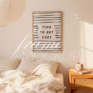 以下が含まれることがあります： 「TIME TO GET COZY」の文字が入った額入りのプリントが寝室に飾られています。木製のフレームで、白い背景に黒い横線が入っています。寝具はクリーム色で、黒いストライプが入っています。