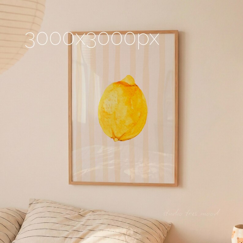 May include: A framed watercolor print of a lemon. The artwork features a yellow lemon against a background of vertical, light-colored stripes. The frame is a light brown color. The text "3000x3000px" is visible in the upper left corner.