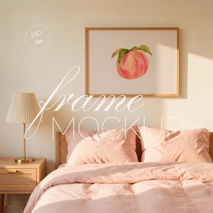 May include: A framed peach watercolor print hangs above a bed with pink bedding. The artwork features a ripe peach with green leaves. A lamp with a pleated shade sits on a wooden nightstand. The image has the text "frame MOCKUP" and "PSD file".
